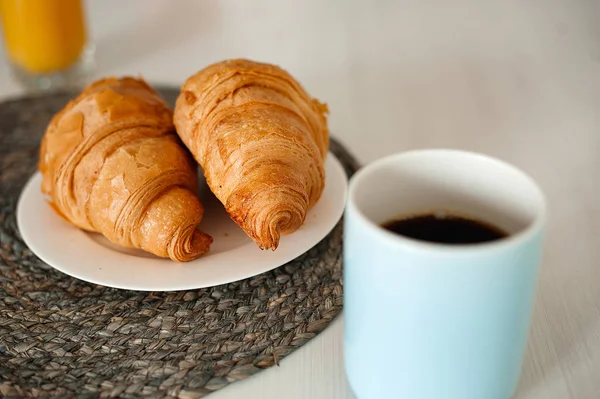 Woman in white shirt drinking coffee with croissants — Stock Photo, Image