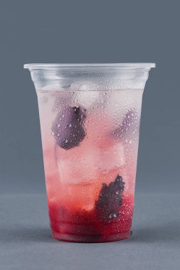 Gri bir arka plan üzerinde fesleğen ve buz küpleri ile soğuk içecek