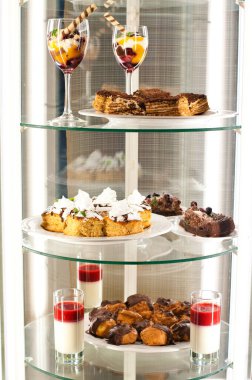 Raflarda çeşitli tatlılar olan bir vitrin.