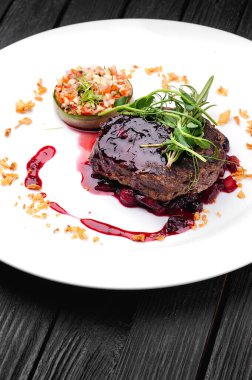 Böğürtlen soslu et ve beyaz tabakta sebze