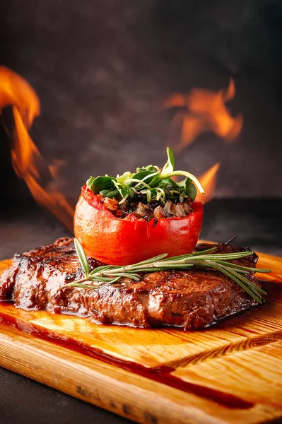 Carne grelhada com legumes em chamas em uma tábua de madeira . — Fotografia de Stock