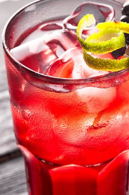 Alkolik, alkolsüz, siyah ahşap masada buzlu kırmızı kokteyl..
