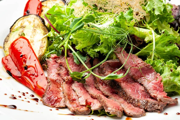 Legumes grelhados com carne e salada fresca em um prato branco . — Fotografia de Stock