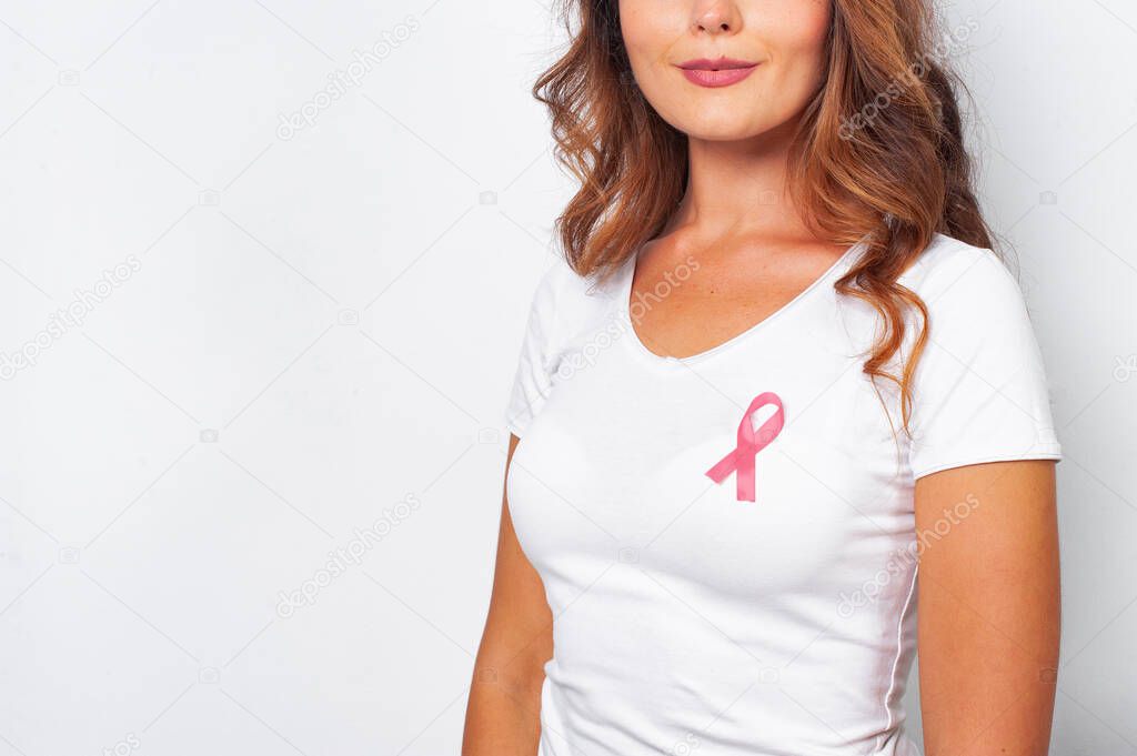 Woman in white t-shirt with pink ribbon supporting breast cancer awareness campaign. Breast Cancer Awareness Month