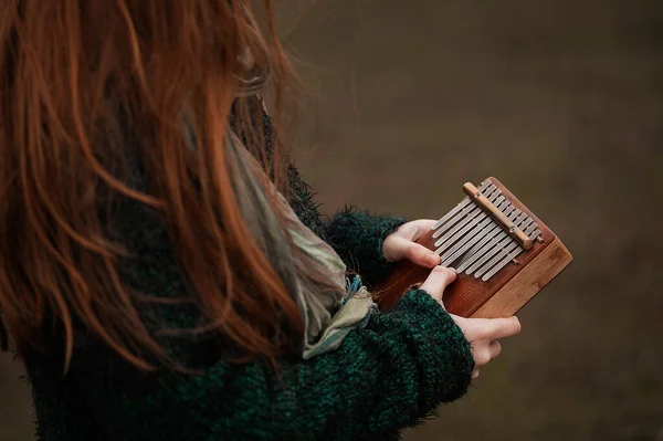 La chica toca la kalimba. Instrumento de percusión. —  Fotos de Stock