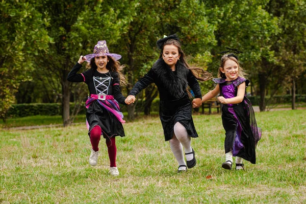 Cadılar Bayramı Kostümlü Mutlu Çocuklar Çimlerde Koşuyor — Stok fotoğraf
