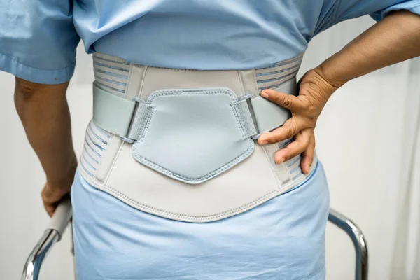 Asya baş ağrısı. Esnek destek kemeri takıp yürüteç takıyor..