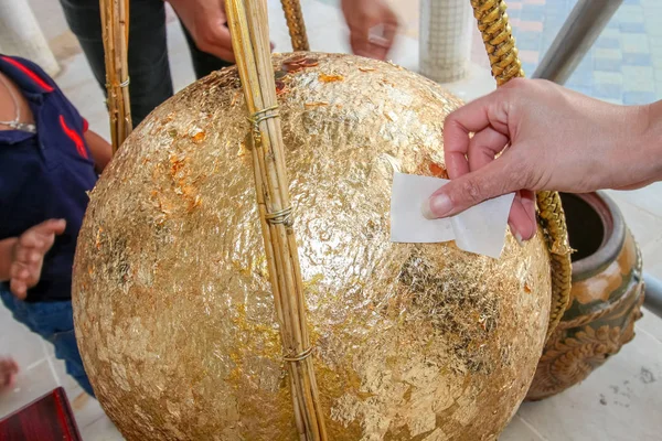 黄金の石造りの彫刻はゴールド シートとコインで Loknimit と呼ばれる球が置かれました — ストック写真