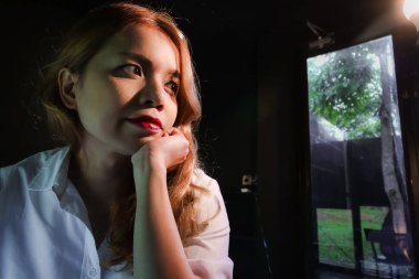 Siyah arka planda kırmızı dudak ve sarı saçlı Tay güzel bayan Gölge ve gölge tarzı