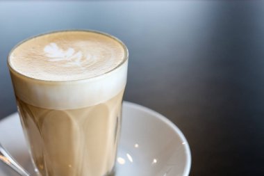 kopya alanı ile siyah masada latte sanat kahve fincan