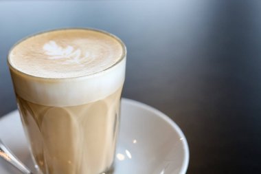 kopya alanı ile siyah masada latte sanat kahve fincan