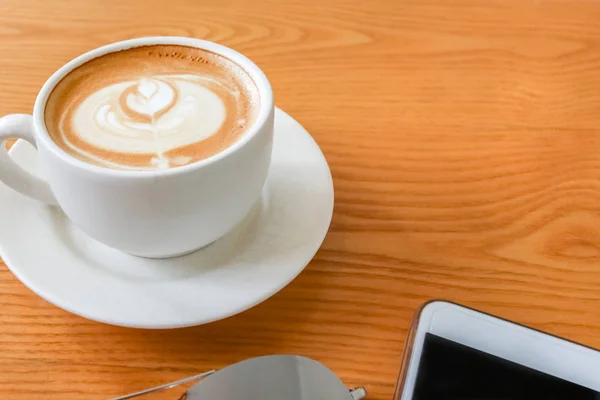 Taza de café arte latte con cuchara y plato en la ba marrón — Foto de Stock