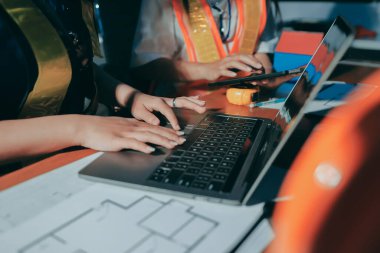 Endüstriyel mühendislerden oluşan bir ekip, fabrikadaki masada bulunan makine planlarını analiz ediyor. Fabrikada ya da üretim tesisinde çalışıyorum..