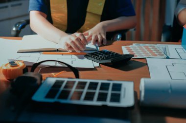 Endüstriyel mühendislerden oluşan bir ekip, fabrikadaki masada bulunan makine planlarını analiz ediyor. Fabrikada ya da üretim tesisinde çalışıyorum..