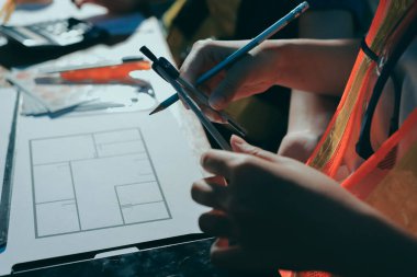 Endüstriyel mühendislerden oluşan bir ekip, fabrikadaki masada bulunan makine planlarını analiz ediyor. Fabrikada ya da üretim tesisinde çalışıyorum..