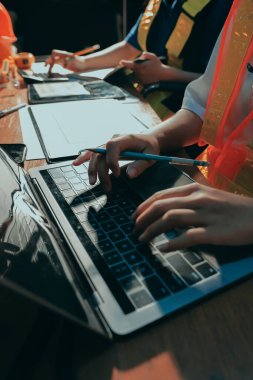 Endüstriyel mühendislerden oluşan bir ekip, fabrikadaki masada bulunan makine planlarını analiz ediyor. Fabrikada ya da üretim tesisinde çalışıyorum..