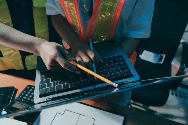 Endüstriyel mühendislerden oluşan bir ekip, fabrikadaki masada bulunan makine planlarını analiz ediyor. Fabrikada ya da üretim tesisinde çalışıyorum..