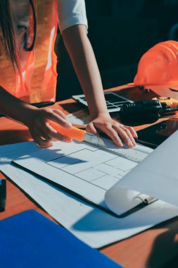 Endüstriyel mühendislerden oluşan bir ekip, fabrikadaki masada bulunan makine planlarını analiz ediyor. Fabrikada ya da üretim tesisinde çalışıyorum..