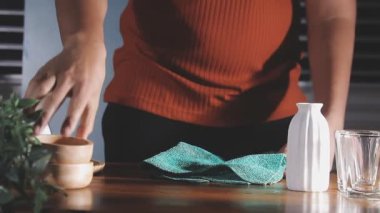 Önlüklü kadın elinde bir kase taze yeşil çay tutuyor.