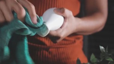 Genç bir kadın elinde bir şişe şampuan tutuyor.