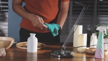 Mutfak masasını sprey şişeyle temizleyen kadın.
