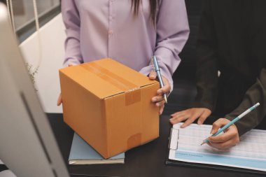 Küçük işletmeler kurma portresi KOBİ sahipleri ve iki Asyalı kadın online siparişleri kontrol ediyor. Ev işlerinde çalışan kutucuklarla çalışan ürünleri satıyorlar.