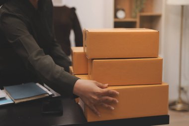 Küçük işletmeler kurma portresi KOBİ sahipleri ve iki Asyalı kadın online siparişleri kontrol ediyor. Ev işlerinde çalışan kutucuklarla çalışan ürünleri satıyorlar.