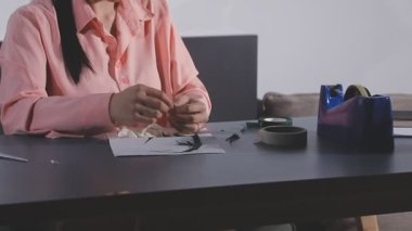 Kadın elleri elinde beyaz bir kağıt kalem ve bir fincan kahveyle