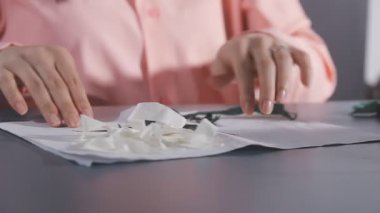 Bir kadının elleri beyaz bir kağıt tutuyor.