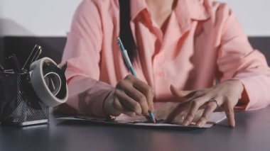 Kadın el yazısı bir deftere kalem ve yazı yazıyor.