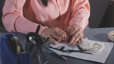 Kadın ressam mürekkep ve kalemle kağıda çiziyor.