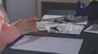 Beyaz kağıt çarşaf tutan bir kadının yakın plan fotoğrafı.