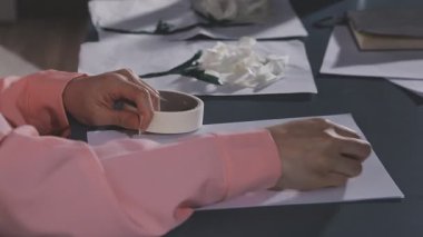 Kadın kalemle kağıt üzerinde çalışıyor.