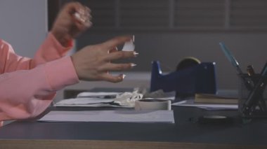 Masada elinde kalem tutan kadın.