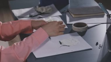 Beyaz gömlekli, siyah elbiseli, bıçaklı bir kadın.