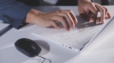 Ofisteki bilgisayar klavyesinde yazan işadamı, kapat