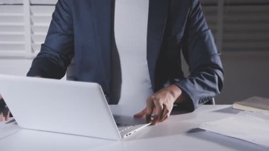 genç işadamı ofiste bir dizüstü bilgisayar kullanarak