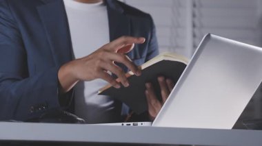 İş adamı ofiste kitap okuyor.