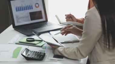 Ofiste bilgisayar ve belgelerle çalışan iş kadını