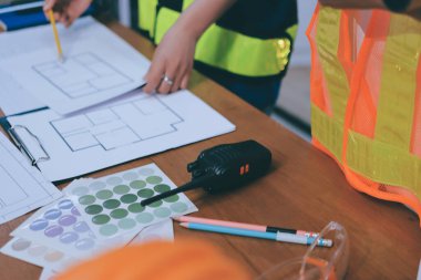 Endüstriyel mühendislerden oluşan bir ekip, fabrikadaki masada bulunan makine planlarını analiz ediyor. Fabrikada ya da üretim tesisinde çalışıyorum..