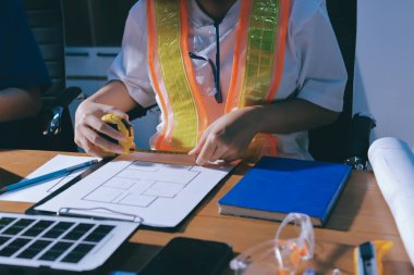 Endüstriyel mühendislerden oluşan bir ekip, fabrikadaki masada bulunan makine planlarını analiz ediyor. Fabrikada ya da üretim tesisinde çalışıyorum..