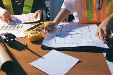 Endüstriyel mühendislerden oluşan bir ekip, fabrikadaki masada bulunan makine planlarını analiz ediyor. Fabrikada ya da üretim tesisinde çalışıyorum..