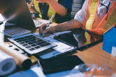 Endüstriyel mühendislerden oluşan bir ekip, fabrikadaki masada bulunan makine planlarını analiz ediyor. Fabrikada ya da üretim tesisinde çalışıyorum..