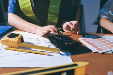 Endüstriyel mühendislerden oluşan bir ekip, fabrikadaki masada bulunan makine planlarını analiz ediyor. Fabrikada ya da üretim tesisinde çalışıyorum..