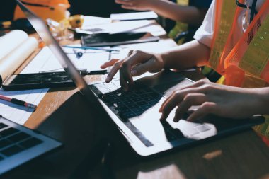 Endüstriyel mühendislerden oluşan bir ekip, fabrikadaki masada bulunan makine planlarını analiz ediyor. Fabrikada ya da üretim tesisinde çalışıyorum..
