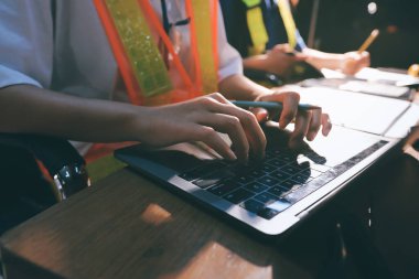 Endüstriyel mühendislerden oluşan bir ekip, fabrikadaki masada bulunan makine planlarını analiz ediyor. Fabrikada ya da üretim tesisinde çalışıyorum..