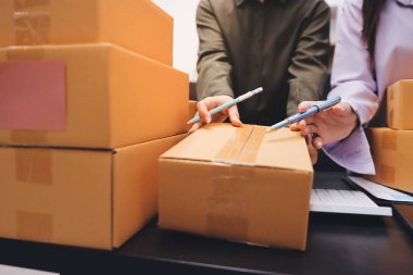 Küçük işletmeler kurma portresi KOBİ sahipleri ve iki Asyalı kadın online siparişleri kontrol ediyor. Ev işlerinde çalışan kutucuklarla çalışan ürünleri satıyorlar.