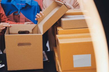 Küçük işletmeler kurma portresi KOBİ sahipleri ve iki Asyalı kadın online siparişleri kontrol ediyor. Ev işlerinde çalışan kutucuklarla çalışan ürünleri satıyorlar.