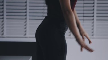 Stüdyoda poz veren siyah elbiseli genç kadın.