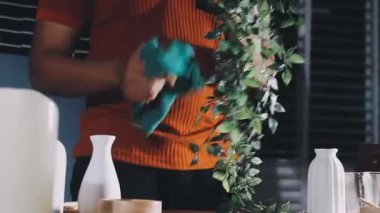 close up of a woman holding a glass jar of fresh mint in a kitchen